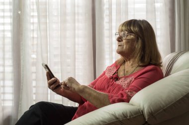 Daha yaşlı bir kadın sosyal uzaklıkla buluşurken iletişim kurmak için modern teknolojileri kullanıyor.