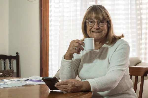 older woman using modern technologies on her devices to communicate while meeting social distancing