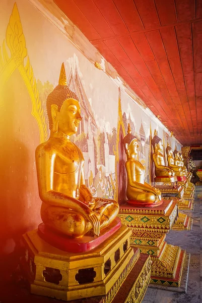 Altın Buddha heykeli turuncu ışık ile zarafeti.