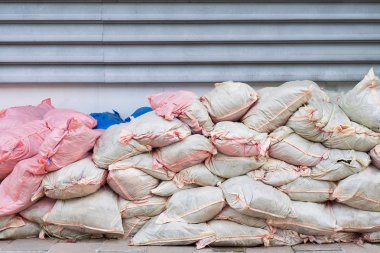 Atık yığınları çuval beyaz ve pembe duvar tarafından yerleştirilen.