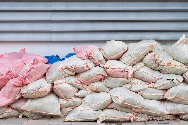 Atık yığınları çuval beyaz ve pembe duvar tarafından yerleştirilen.