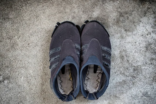 Beton zemin üzerinde eski ayakkabı.
