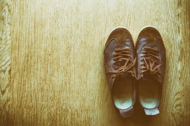 Bir ahşap zemin, vintage renk tonu üstten görünüm üzerinde eski kahverengi spor ayakkabı.