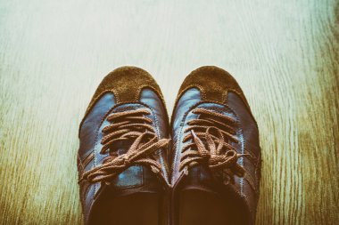 Bir ahşap zemin, vintage renk tonu üstten görünüm üzerinde eski kahverengi spor ayakkabı.
