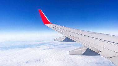 Bulutların üstünde mavi gökyüzü üzerinde uçağın penceresinden görüntülemek.