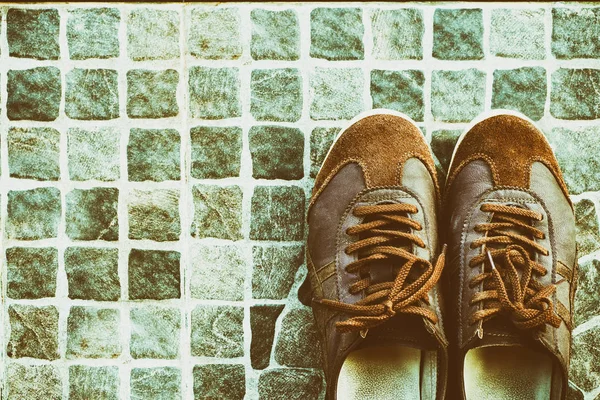 Eski kahverengi spor ayakkabılar üzerinde zemin üstü göster.