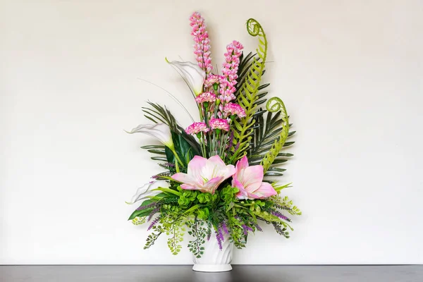 Ahşap masa üzerinde beyaz bir kavanoza buket.