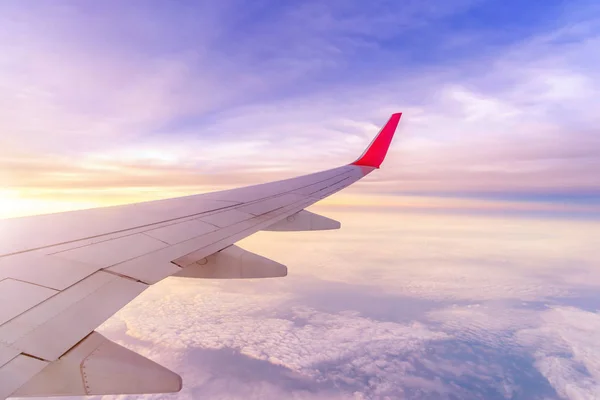 Uçak sağ kanatta gökyüzü sabahları gündoğumu şafakta bulutların üstünde.