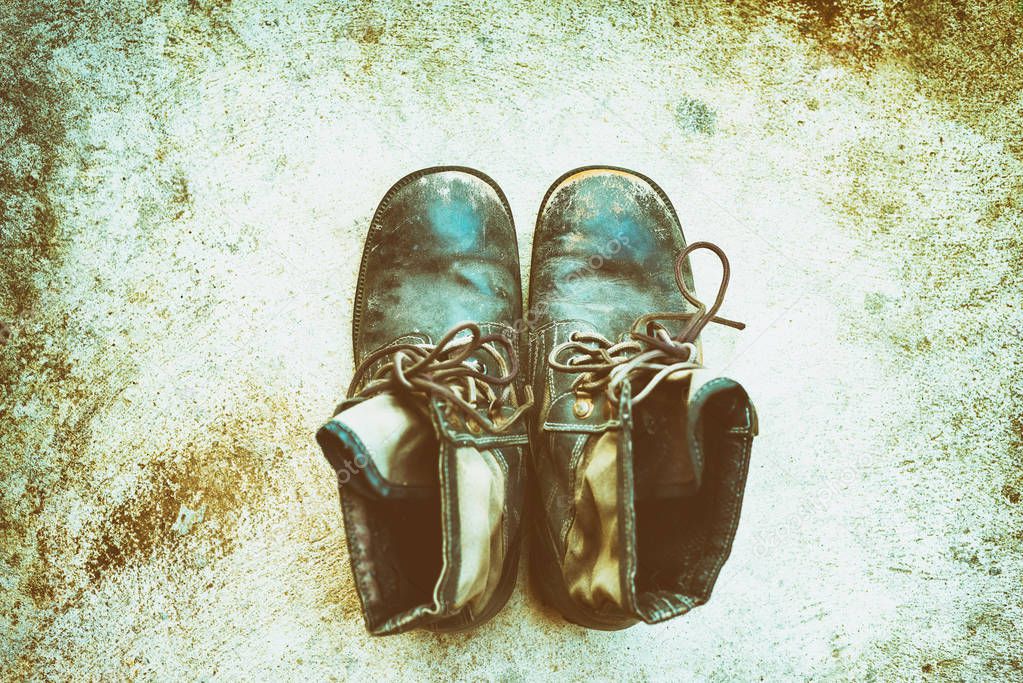 Old Military boots placed on the floor, Vintage color tone top view.