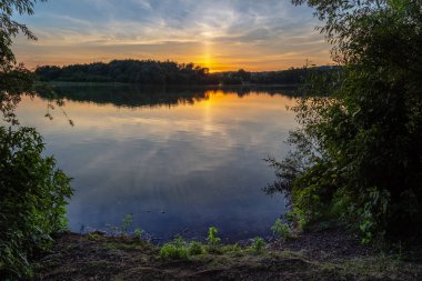 İngiltere'de küçük bir göl üzerinde günbatımı.