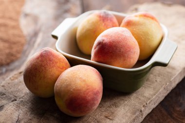 Ahşap, tropikal meyve bir kase içinde olgun şeftali