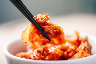 Kimchi lahana, yemek için yemek çubuğu tutan el Kore yemeği