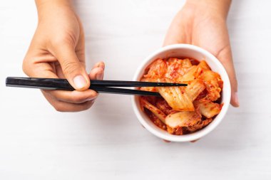 Bir kase ve chopsticks için en iyi görünümü, Kore yemeği yemek kimchi lahana tutan el