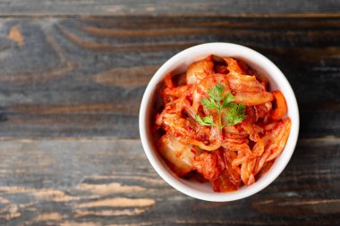 Ahşap arka plan, üstten görünüm, Kore yemeği bir kasede kimchi lahana