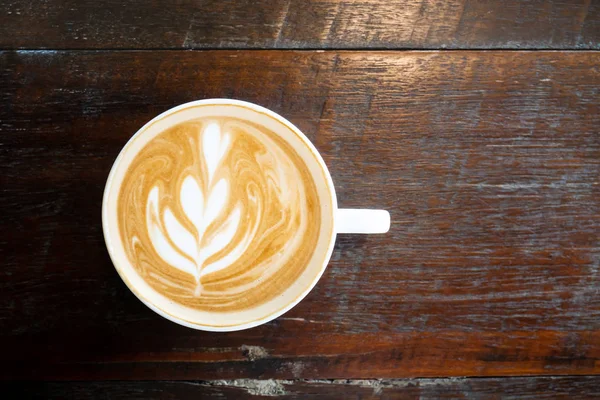 Latte sanat kafede, üstten görünüm ahşap masa üzerinde kahve fincan