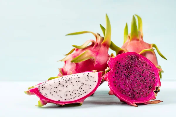 Half and sliced dragon fruit on color background, tropical fruit