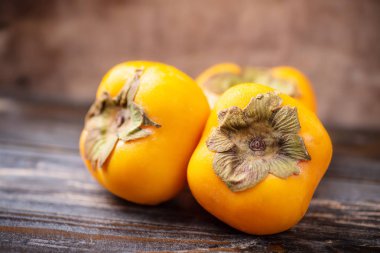 Ahşap masa, sağlıklı meyve üzerinde olgunlaşmış Trabzon hurması, yakın çekim