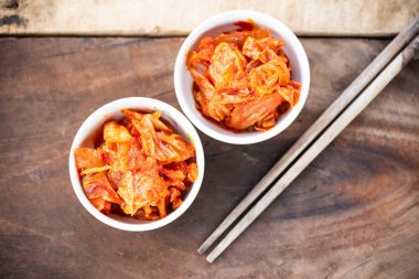 Ahşap masa, Kore yemeği yemek için yemek çubukları ile bir kase kimchi lahana
