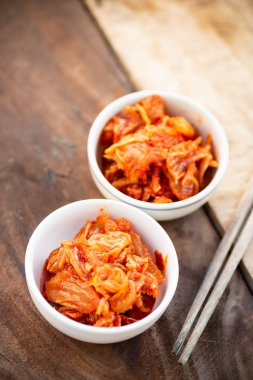 Ahşap masa, Kore yemeği yemek için yemek çubukları ile bir kase kimchi lahana
