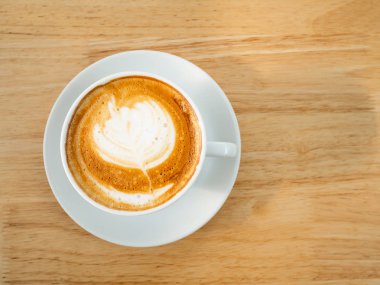 Latte sanat ahşap arka planda, üstten görünüm kahve fincan