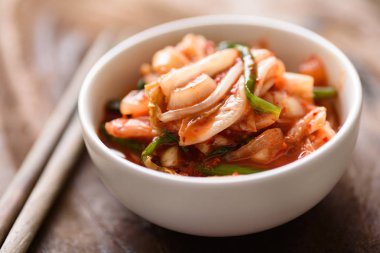 Chopsticks ile bir kase içinde kimchi lahana