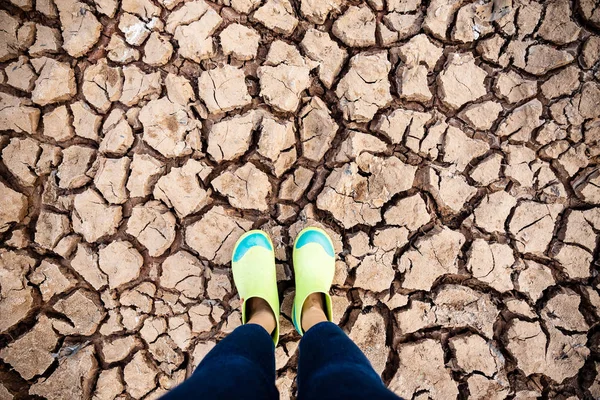 Woman wear rubber shoes standing on drought land