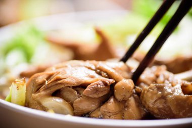 Pirinç eriştesi içinde haşlanmış tavuk kanadı yeme