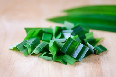 Sliced pandan leaf on cutting board preparing for cooking clipart