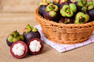Kahverengi kumaş arka plan üzerinde sepet içinde Mangosteen, Tay meyve