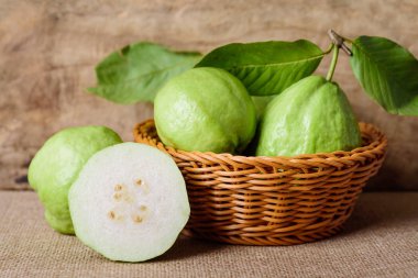 Tahta arka planda sepetteki taze guava meyvesi, tropikal meyve.