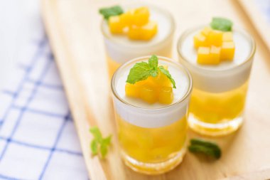 Thai tatlı mango pudingi, olgun mango agara bandırılmış ve hindistan cevizi sütü jölesi üzerinde nane yaprağı ile süslenmiş.