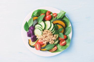 Sebzeli salata kinoası tohumu (marul, salatalık, domates, balkabağı, tatlı patates ve fesleğen yaprağı), sağlıklı vejetaryen yemeği