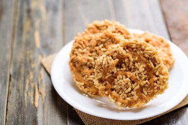 Tayland yemeği, beyaz tabağa şeker serpiştirilmiş tatlı çıtır pirinç (Khao Tan)