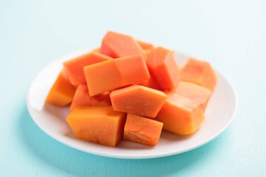 Beyaz tabakta dilimlenmiş papaya meyvesi yemeye hazır, tropik meyve, sağlıklı beslenme.
