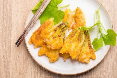 Kızarmış balkabağı çiçekleri ve yemek için çubuklar.