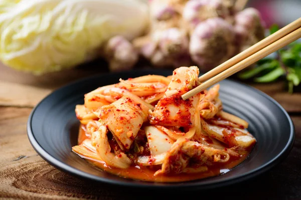 Tabakta kimchi lahana, çubuklarla yemek, Kore yemeği.