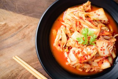 Kore yemeği, tabakta kimchi lahanası, ahşap arka planda çubuklar, Top View.