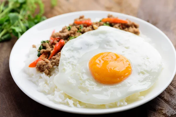 Tayland yemeği, kızarmış kutsal fesleğen, kıymalı domuz eti ve pilavla birlikte kızarmış yumurta (Pad Kaprao Moo Kai Dao)