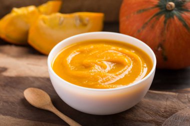 Kasede balkabağı çorbası ve ahşap arka planda taze balkabağı.