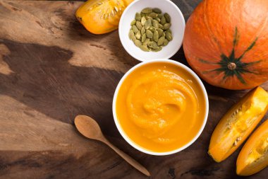 Tohumlu kabak çorbası ve ahşap arka planda taze balkabağı, Top View