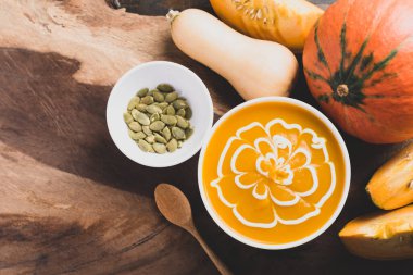 Tohumlu kabak çorbası ve ahşap arka planda taze balkabağı, Top View