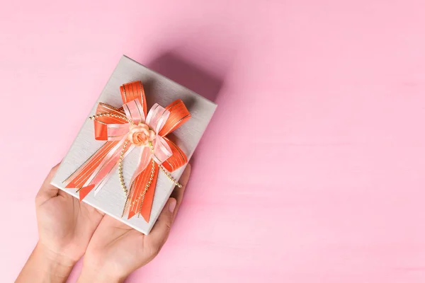 Caja Regalo Con Cinta Naranja Sujeta Mano Sobre Fondo Rosa — Foto de Stock