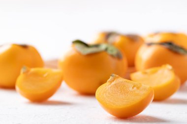 Beyaz arka planda dilimlenmiş taze olgun hurma, sonbahar tatlı meyvesi