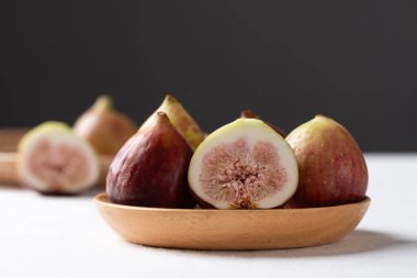 Tahta tabakta taze incir, beyaz ve siyah arka plan, sonbahar meyvesi.