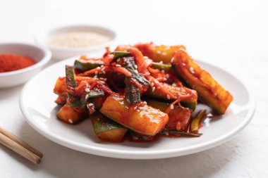 Beyaz tabakta Kore kimchi salatalığı, Kore mezesi, ev yapımı yemek.