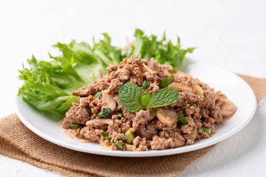 Beyaz arka planda yerel Tayland yemeği, baharatlı kıymalı domuz salatası (Larb Moo).