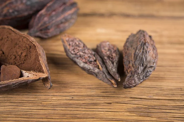 Cocoa beans on a wooden background, cocoa and dark bitter chocolate, Raw cocoa on a brown background