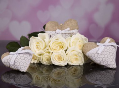 Beyaz gül buketi, kalpler, melekler malzemeden. Sevgililer.