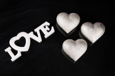 Sevgililer günü için sözler sevgi ile siyah bir zemin üzerine gümüş kalpler.