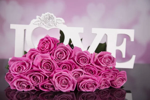 A bouquet of pink roses on a black background with the words love.